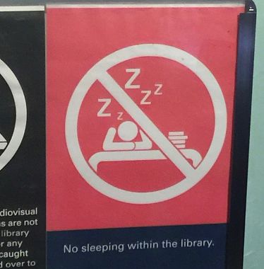 Il cartello "Non dormite in biblioteca" a Singapore